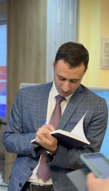 Александр Минаков подписывает учебник после мастер-класса в Национальной библиотеке ЯНАО