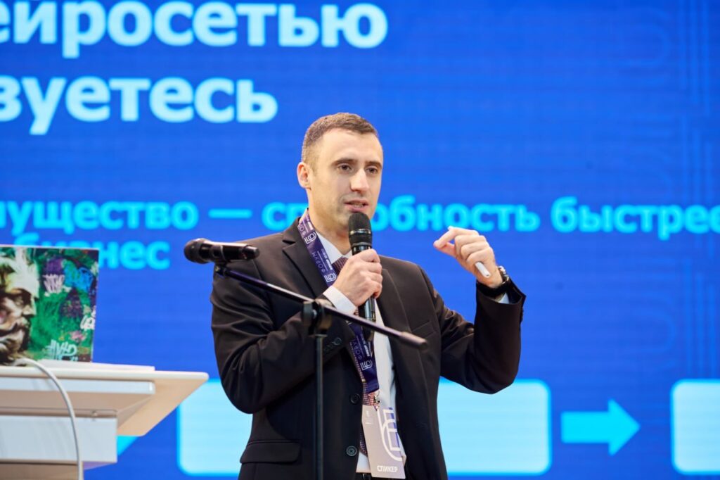 Александр Минаков выступает на форуме с докладом о нейросетях как рабочей среде